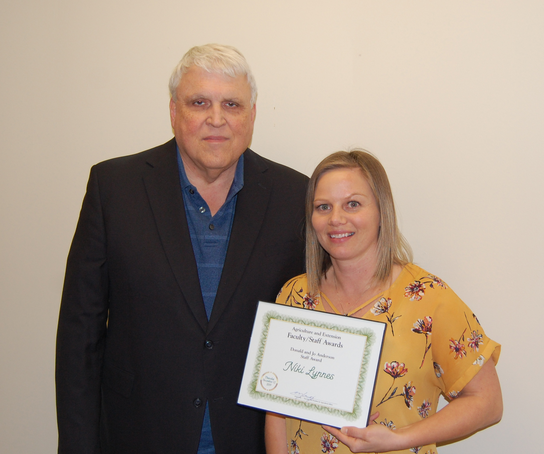 Niki Lynnes, right, receives the Donald and Jo Anderson Staff Award from David Buchanan, associate dean for academic programs. (NDSU photo)