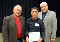 Zhaohui Liu, center, receives the Larson/Yaggie Excellence in Research Award from Robert Yaggie, left, and David Buchanan, associate dean for academic programs. (NDSU photo)