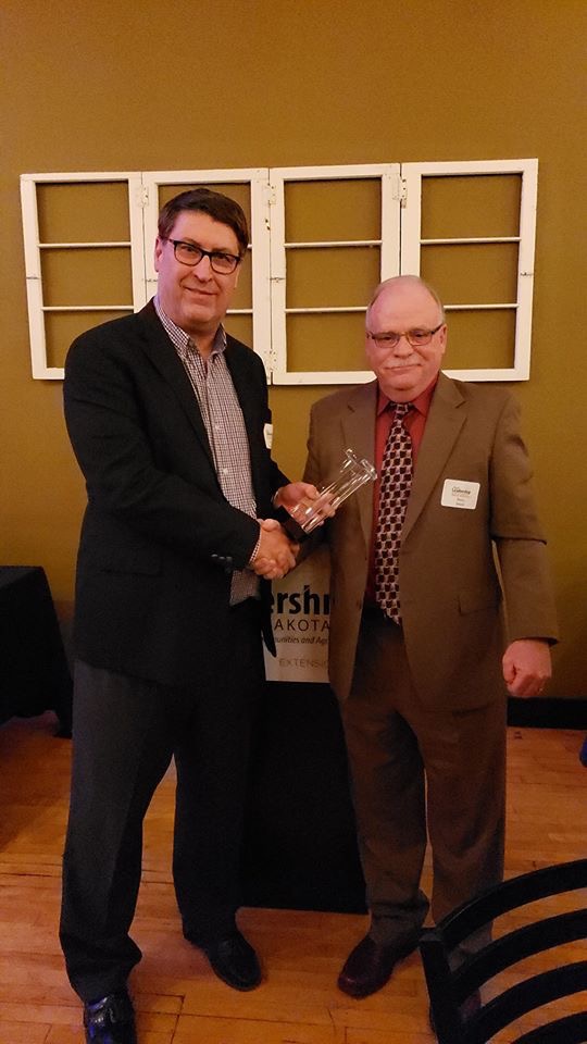 Michael O’Keeffe, left, accepts Rural Leadership North Dakota's Leader Award from Barry Medd, RLND Council chair. (NDSU photo)