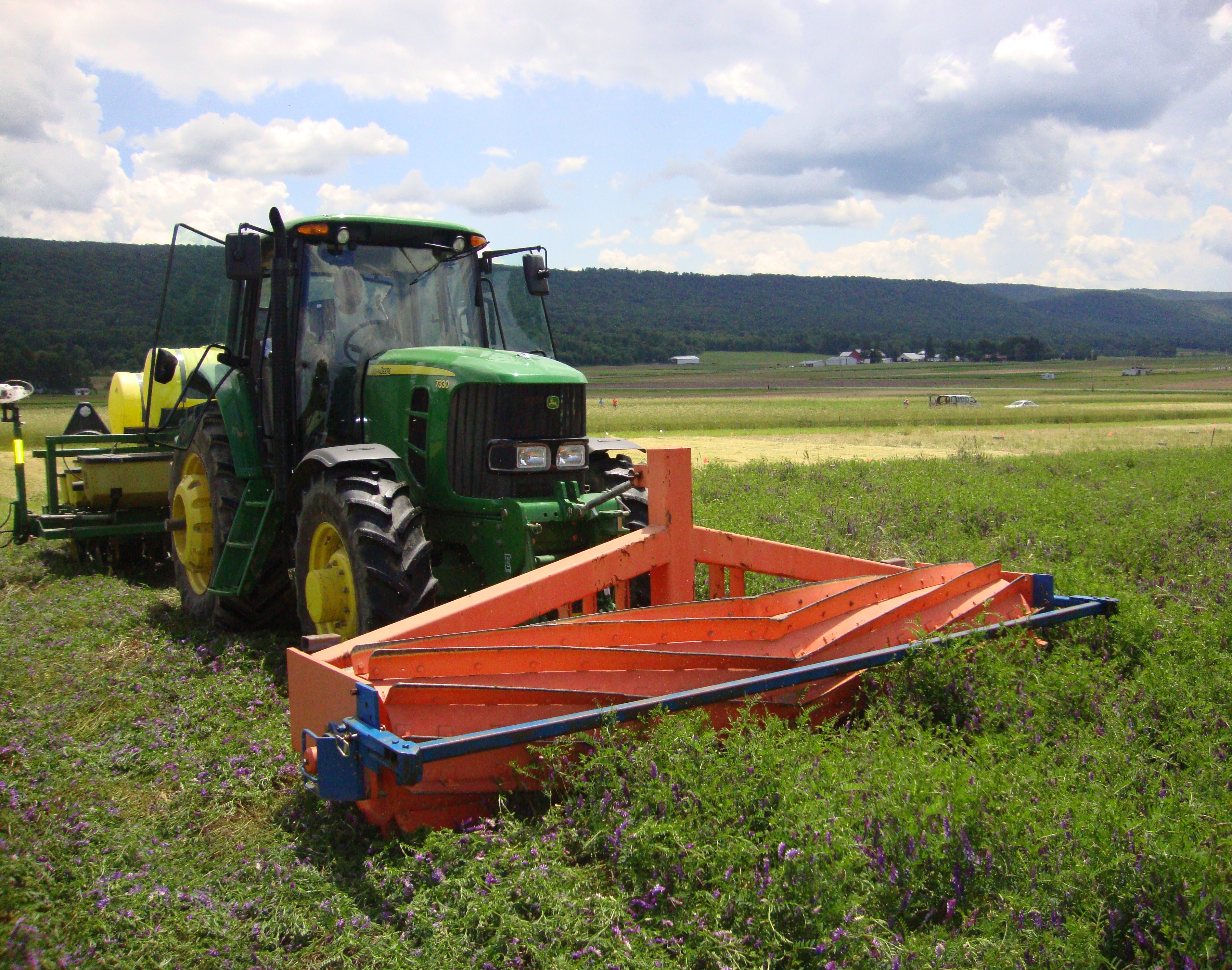 A roller-crimper rolls down a hairy vetch-triticale cover crop. (NDSU photo)