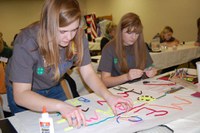Former 4-H youth from Mercer County create a poster for a food drive for the local food pantry. (NDSU photo)