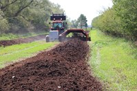 Compost is being turned at the Carrington Research Extension Center as part of a demonstration day. (NDSU photo)