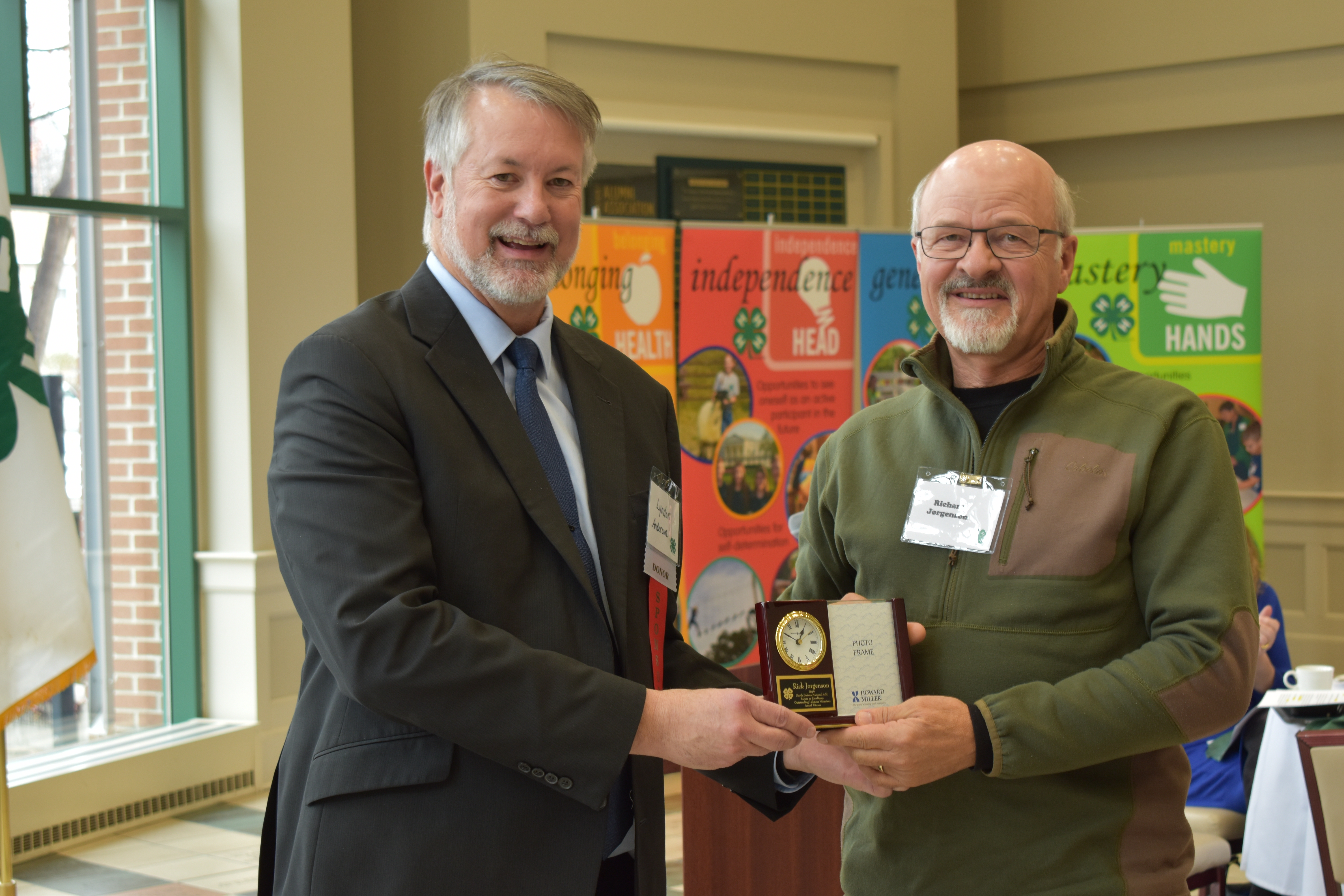 Rick Jorgenson, North Dakota’s Outstanding Lifetime 4-H Volunteer for 2019 (right) receives a gift from Lyndon Anderson, a North Dakota 4-H Foundation board member. (NDSU photo)