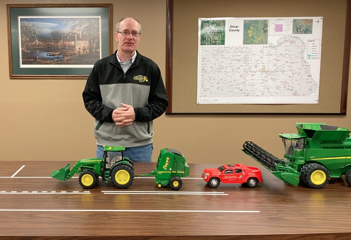 NDSU Extension agent Rick Schmidt uses models to demonstrate road safety involving farm equipment. (NDSU photo)