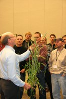 NDSU Extension agronomist Joel Ransom, left, talks to Best of the Best in Wheat Research and Marketing meeting participants about wheat staging and fungicide use. (NDSU photo)