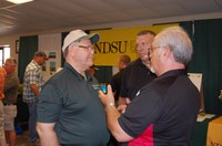 Ken Hellevang, NDSU Extension agricultural engineer (left), talks to visitors at the Big Iron farm show. (NDSU photo)