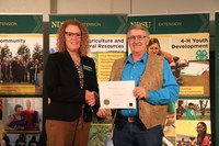 NDSU Extension agent Dan Folske (R) received the Distinguished Service Award. Pictured with Jodi Bruns (L), NDSU leadership and civic engagement specialist and president of Upsilon chapter of Epsilon Sigma Phi.