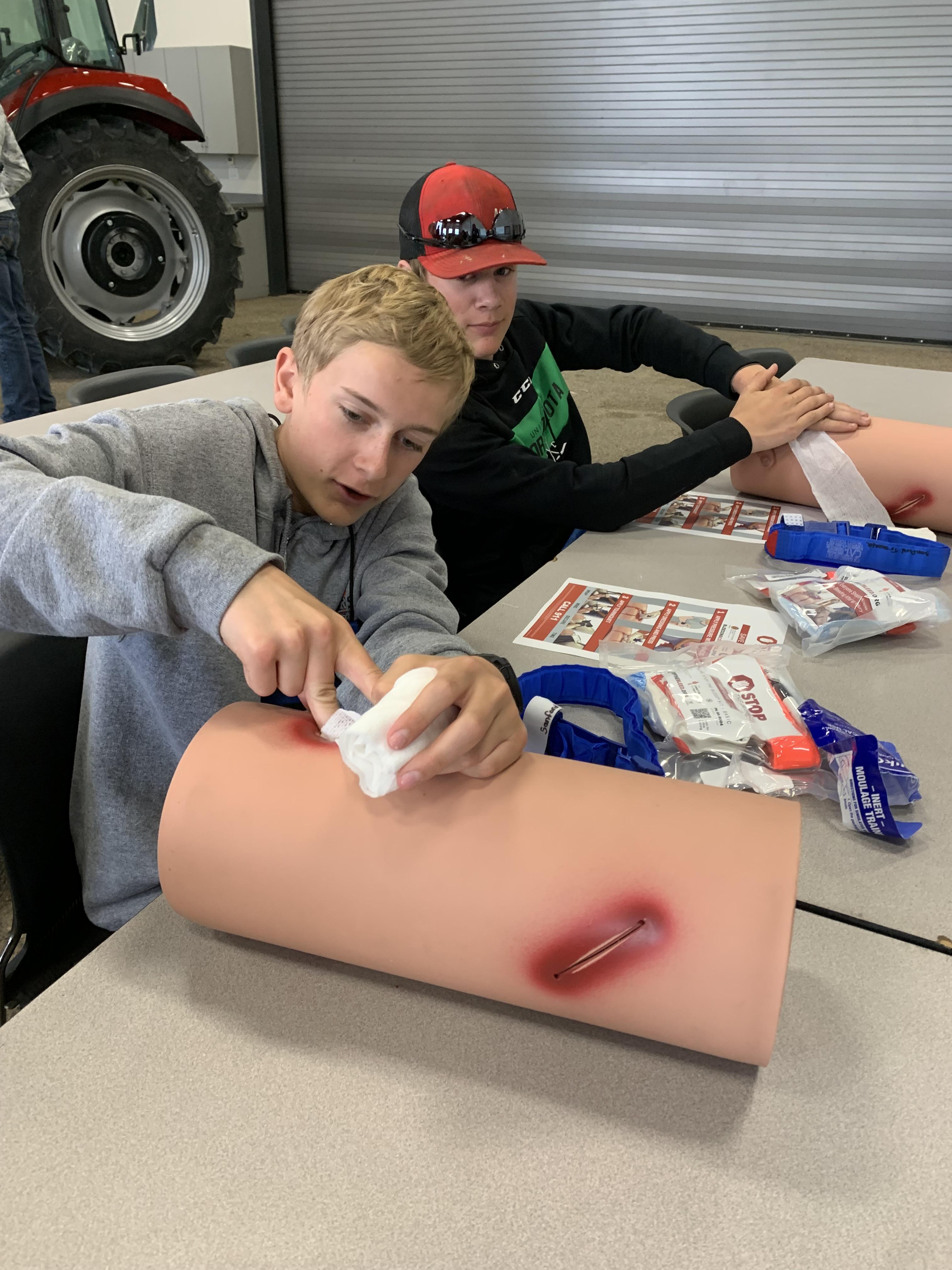 Youth at an NDSU Extension tractor safety camp practice Stop the Bleed techniques. (NDSU photo)