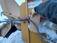 Pinhole leaks in hydraulic hose lines are extremely dangerous and can be impossible to see with the naked eye. Using a piece of cardboard to check for leaks protects hands and fingers. (NDSU photo)