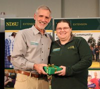 Angie Johnson (right), NDSU Extension farm and ranch safety coordinator, received the NDSU Extension Communicator of the Year award. Representing the North Dakota chapter for the Association for Communication Excellence is Bruce Sundeen, electronic media specialist. (NDSU photo)