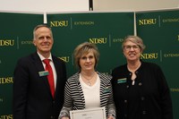 Millie Steckler (center) is recognized for 10 years of service to NDSU Extension. Also pictured are Greg Lardy, vice president for NDSU Agriculture, and Lynette Flage, associate director for NDSU Extension. (NDSU photo)