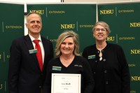 Laura Morelli (center) is recognized for 20 years of service to NDSU Extension. Also pictured are Greg Lardy, vice president for NDSU Agriculture, and Lynette Flage, associate director for NDSU Extension. (NDSU photo)