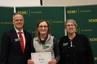 Deb Evenson (center) is recognized for 25 years of service to NDSU Extension. Also pictured are Greg Lardy, vice president for NDSU Agriculture, and Lynette Flage, associate director for NDSU Extension. (NDSU photo)
