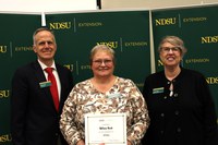 Melanie Hesch (center) is recognized for 25 years of service to NDSU Extension. Also pictured are Greg Lardy, vice president for NDSU Agriculture, and Lynette Flage, associate director for NDSU Extension. (NDSU photo)