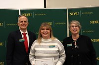 Robbi Hopkins (center) is recognized for 25 years of service to NDSU Extension. Also pictured are Greg Lardy, vice president for NDSU Agriculture, and Lynette Flage, associate director for NDSU Extension. (NDSU photo)