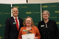 Cindy Olson (center) is recognized for her 30 years of service to NDSU Extension. Also pictured are Greg Lardy, vice president for NDSU Agriculture, and Lynette Flage, associate director for NDSU Extension. (NDSU photo)