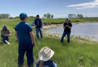 An NDSU Extension agent demonstrates how to use a TDS meter to screen a livestock water source. (NDSU photo)