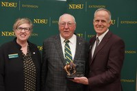 Larry Hoffmann (center), Cass County farmer, is honored with the 2025 Friend of Extension award by Lynette Flage (left), NDSU Extension associate director, and Greg Lardy (right), Joe and Norma Peltier Vice President for Agriculture at NDSU. (NDSU photo)