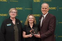 Nancy Nikolas-Maier (center), director of Adult and Aging Services at the North Dakota Department of Health & Human Services, is honored with the 2025 Friend of Extension award by Lynette Flage (left), NDSU Extension associate director, and Greg Lardy (right), Joe and Norma Peltier Vice President for Agriculture at NDSU. (NDSU photo)