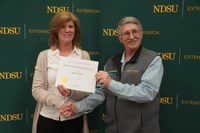 Jane Hayen (left), administrative assistant in Cavalier County, is honored with the Epsilon Sigma Phi State Meritorious Support Staff Award by Dan Folske (right), NDSU Extension agriculture and natural resources agent in Burke County. (NDSU photo)