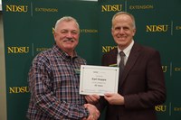 Karl Hoppe (left), NDSU Extension livestock systems specialist at NDSU's Carrington Research Extension Center, is honored for 35 years of service by Greg Lardy (right), Joe and Norma Peltier Vice President for Agriculture at NDSU. (NDSU photo)