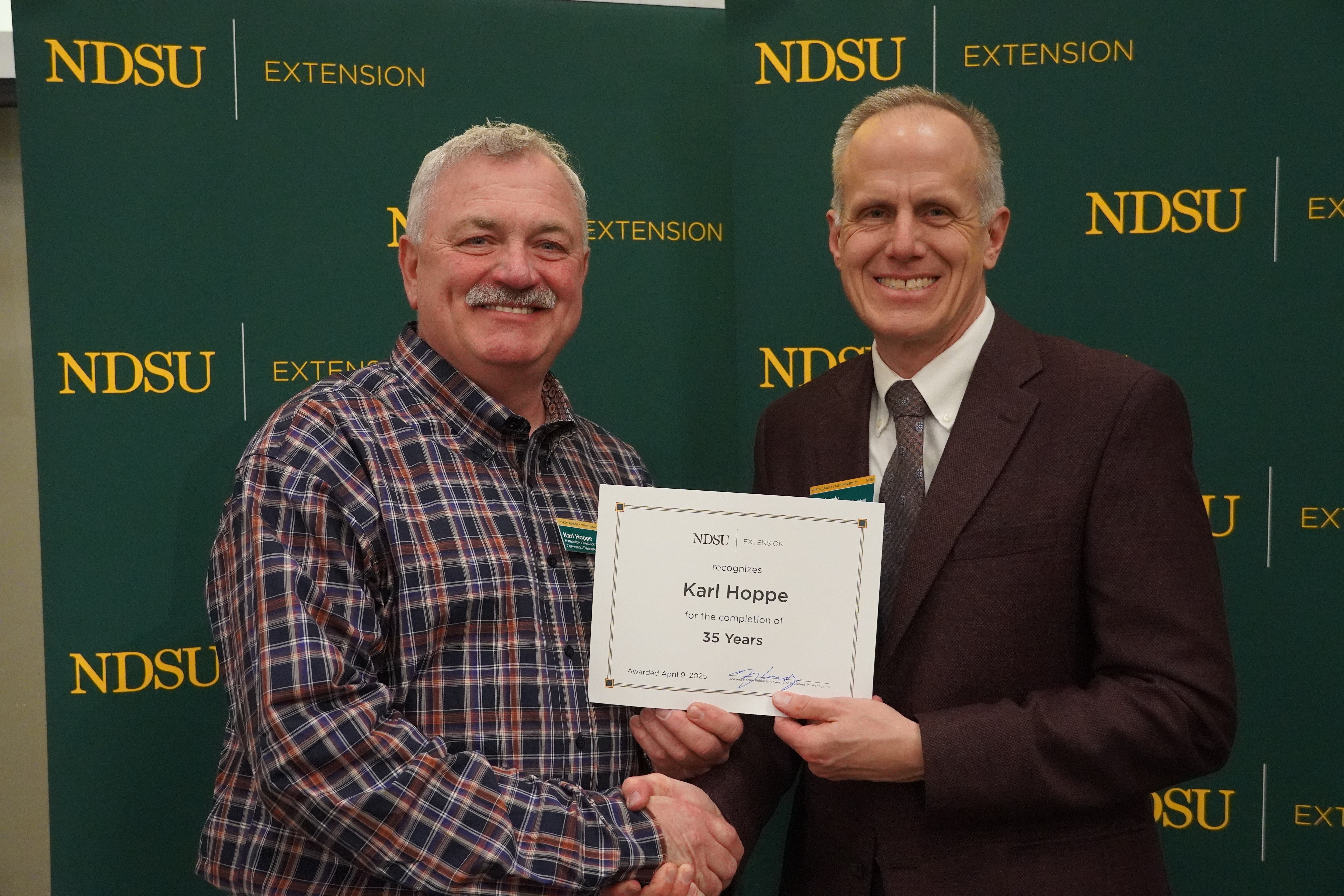 Karl Hoppe (left), NDSU Extension livestock systems specialist at NDSU's Carrington Research Extension Center, is honored for 35 years of service by Greg Lardy (right), Joe and Norma Peltier Vice President for Agriculture at NDSU. (NDSU photo)