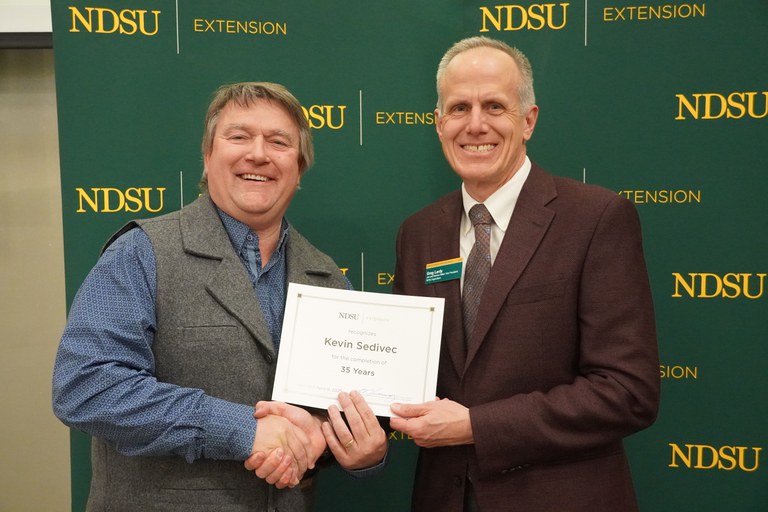Kevin Sedivec (left), NDSU Extension rangeland management specialist at NDSU's Central Grasslands Research Extension Center, is honored for 35 years of service by Greg Lardy (right), Joe and Norma Peltier Vice President for Agriculture at NDSU. (NDSU photo)