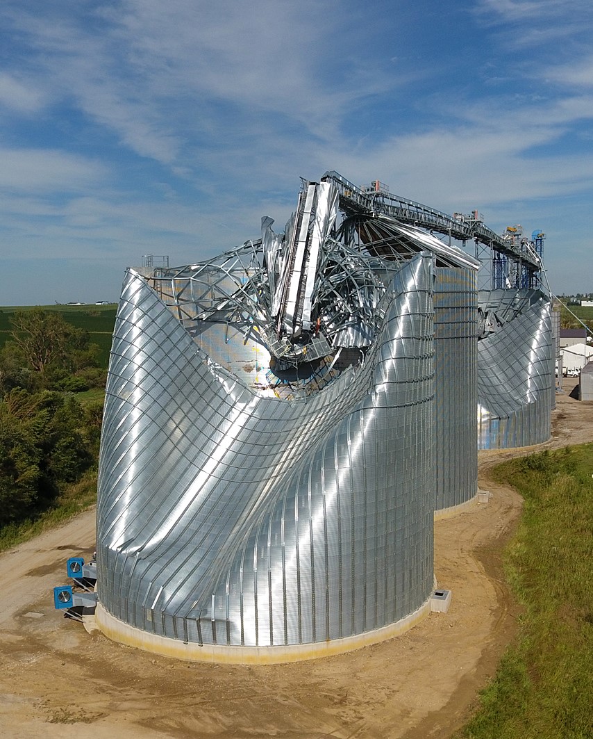 Wind load on a bin wall pushes in on the windward side of the bin while it pulls out away in the remaining directions, which has bent this Iowa bin out of shape. (Photo by the National Weather Service)