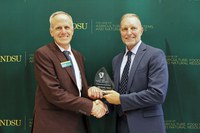Greg Lardy, Joe and Norma Peltier Vice-President for Agriculture at NDSU (left), presents Michael Uetz (right) the 2025 NDSU CAFSNR Distinguished Alumni Award. (NDSU photo)