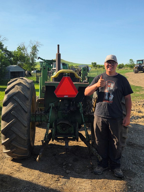 Carter Roth of Grant County, North Dakota, placed fourth for installing a slow-moving vehicle sign on an open-cabbed John Deere tractor. (NDSU photo)
