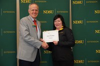 Diane Herding (right), administrative assistant in Cass County, is recognized for her 25 years of service by Greg Lardy (left), Joe and Norma Peltier Vice President for Agriculture at NDSU. (NDSU photo)