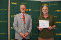 John Grindahl (right), graphic designer for NDSU Agriculture Communication, is recognized for his 35 years of service by Greg Lardy (left), Joe and Norma Peltier Vice President for Agriculture at NDSU. (NDSU photo)