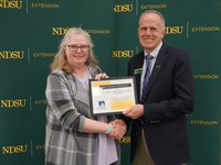 Jennifer Hansen (left), finance director of the Northarvest Bean Growers Association, accepts the Friend of the North Dakota Extension Association of Family and Consumer Sciences award from Greg Lardy (right), Joe and Norma Peltier Vice President for Agriculture at NDSU. (NDSU photo)