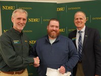 Joe Ikley (center), NDSU Extension weed specialist, is honored with the Communicator of the Year Award by Bruce Sundeen (left), electronic media specialist for NDSU Agriculture Communication, and Greg Lardy (right), Joe and Norma Peltier Vice President for Agriculture at NDSU.