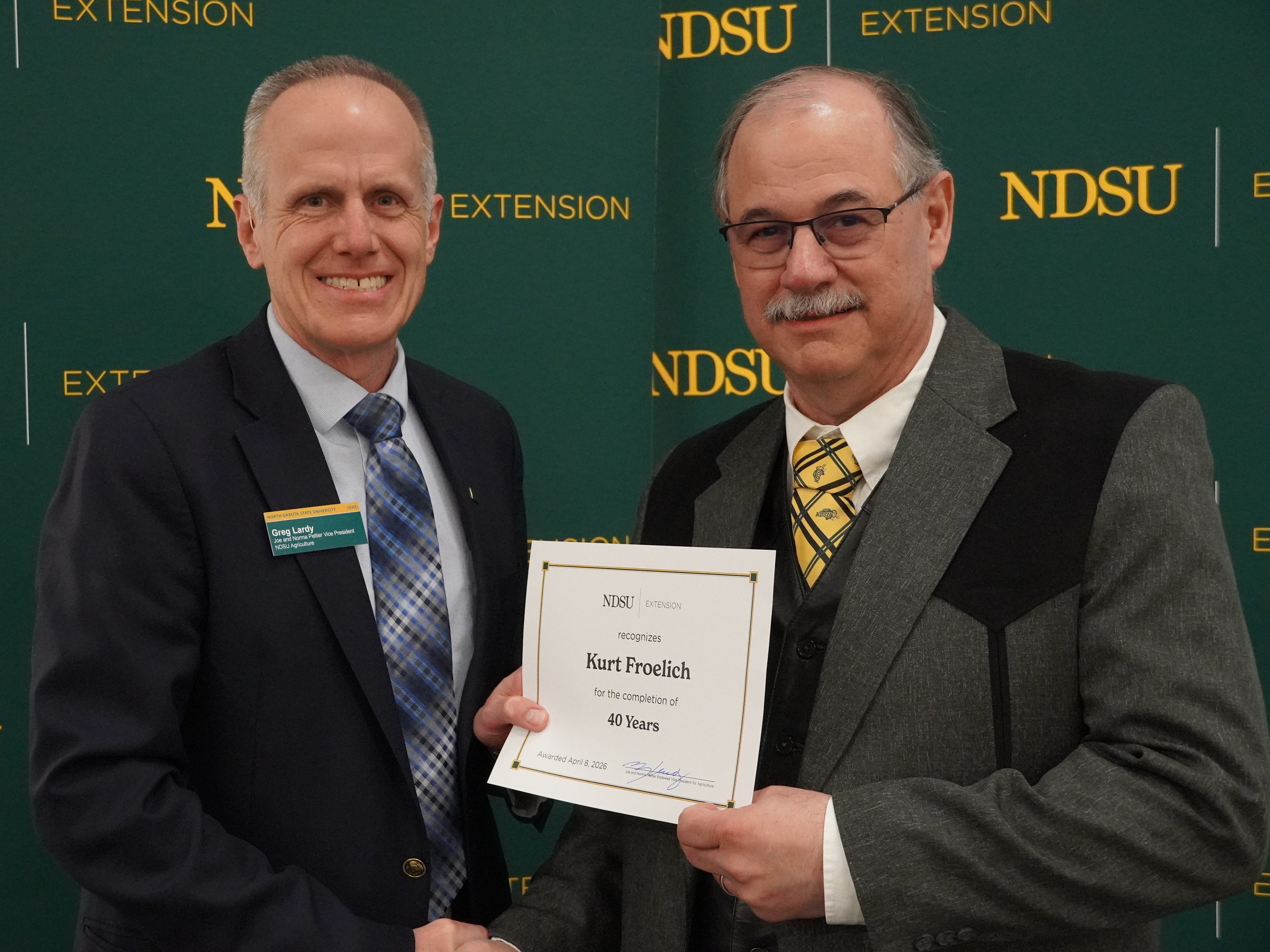 Kurt Froelich (right), NDSU Extension agriculture and natural resources agent in Stark/Billings County, is honored for 40 years of service by Greg Lardy (left), Joe and Norma Peltier Vice President for Agriculture at NDSU. (NDSU photo)
