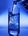 glass of water being poured from pitcher. blue background.jpg