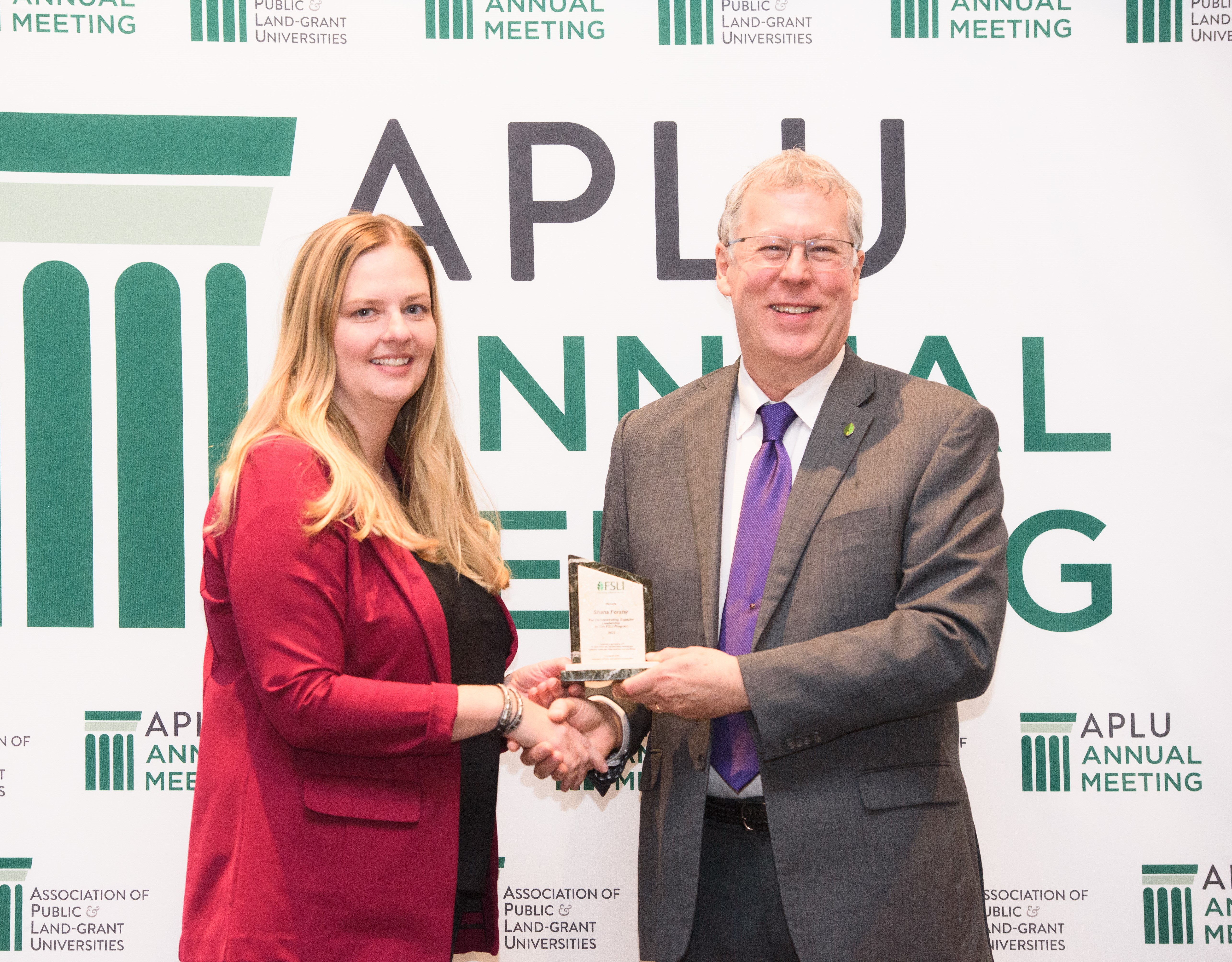 Shana Forster, NDSU, receives a recognition award from Food Systems Leadership Institute director Sam Pardue for her achievements as a fellow in the institute.