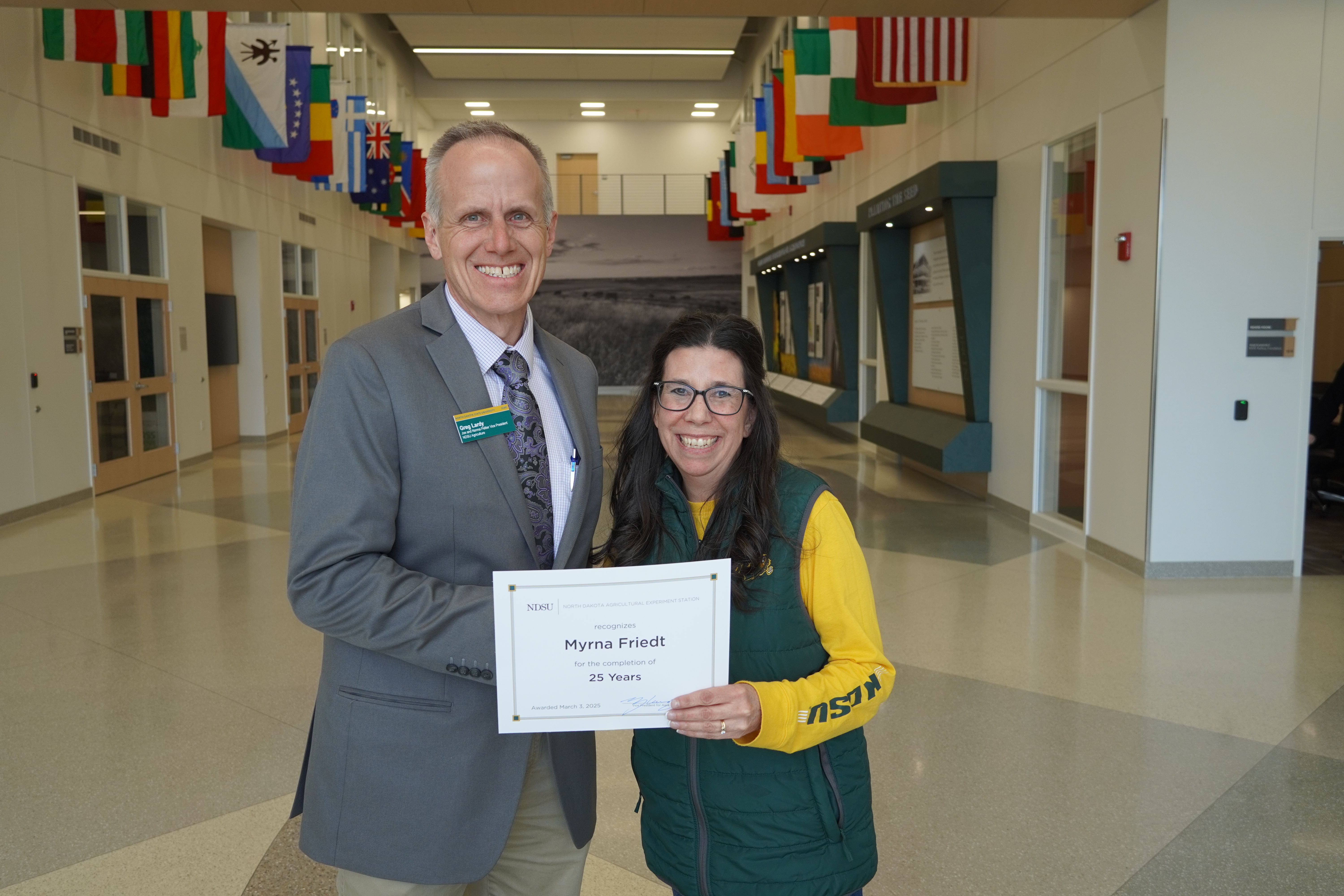 Myrna Friedt (25 years) receives congratulations from Greg Lardy. (NDSU photo)