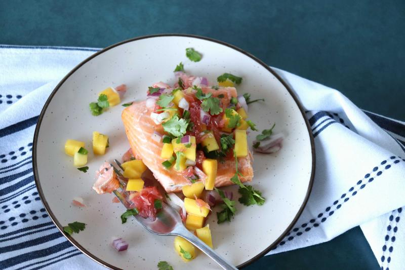 plate with a filet of salmon topped with citrus salsa